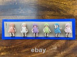 6 clothed antique porcelain dolls on sample card Hertwig & Co