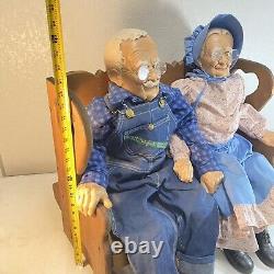 Adorables poupées en porcelaine William Wallace Jr pour grand-mère et grand-père sur un banc à bascule.