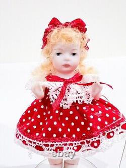 Jeune fille victorienne vintage avec une robe rouge à pois courte - Mini poupée en porcelaine