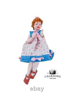 Jeune fille vintage avec robe courte fleurie, cheveux bouclés roux, poupée de porcelaine miniature