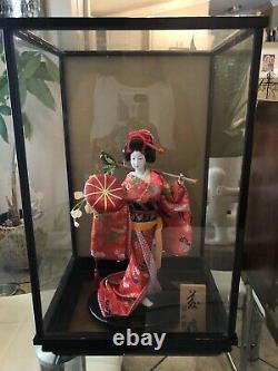 Poupée Japonaise Vintage De Geisha De Porcelaine Dans La Vitrine Avec La Plaque En Bois Signée