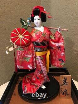 Poupée Japonaise Vintage De Geisha De Porcelaine Dans La Vitrine Avec La Plaque En Bois Signée