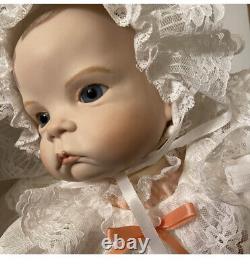 Poupée de bébé en jupon aux yeux bleus et aux cheveux blonds, avec visage et mains en porcelaine réalistes de style vintage