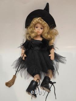 Poupée de sorcière vintage en porcelaine aux cheveux blonds bouclés, coiffée d’un chapeau de sorcière noir
