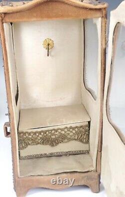 Poupée en bois en porcelaine française ancienne dans une chaise de sedan recouverte de brocart et de velours
