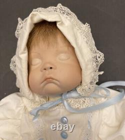 Poupée en porcelaine pour bébé VTG dans une robe de baptême blanche avec des finitions bleues et le visage endormi.