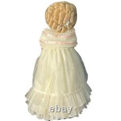 Poupée en porcelaine style vintage, boucles blondes, robe à volants crème avec panier de fleurs