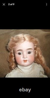 Poupée en porcelaine vintage avec des boucles blondes et un nœud