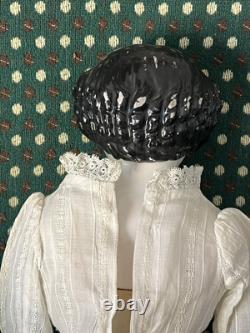 Poupée tête de Chine du 19ème siècle avec bras et bottes en cuir, cheveux noirs à plat.