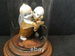 Poupées Kewpie de couple de mariage antiques sur un support dans une vitrine en verre et bois Rose O'Neill