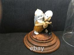 Poupées Kewpie de couple de mariage antiques sur un support dans une vitrine en verre et bois Rose O'Neill