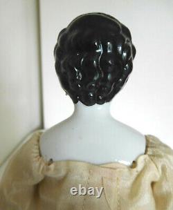 Reproduction d'une poupée ancienne en porcelaine avec des cheveux élégants et des oreilles percées de style vintage