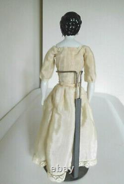 Reproduction d'une poupée ancienne en porcelaine avec des cheveux élégants et des oreilles percées de style vintage