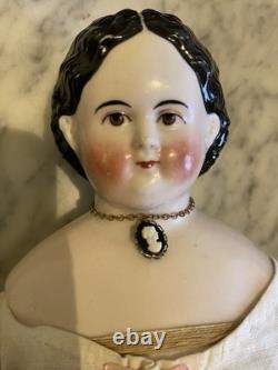 Superbe poupée antique Greiner en porcelaine des années 1850, aux yeux bruns, ravissante tenue d’époque et bottes