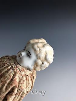 Une poupée à tête en porcelaine ancienne