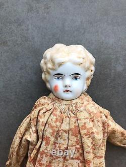 Une poupée à tête en porcelaine ancienne